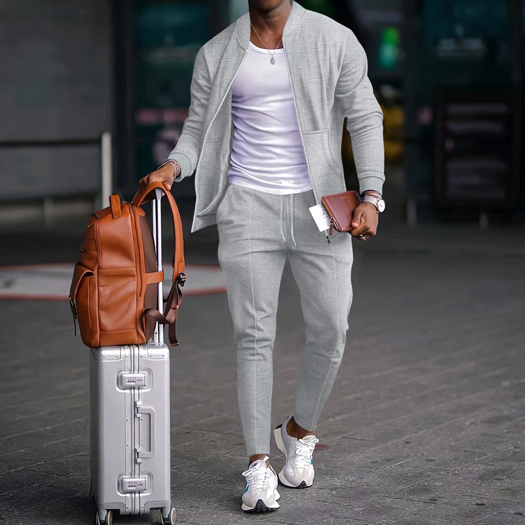 A man wearing a grey MIG & MIK STYLE waffle-knit two-piece set with a zippered jacket and drawstring trousers.